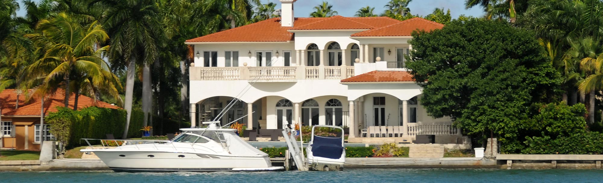 White Mansion With Yacht On A Canal
